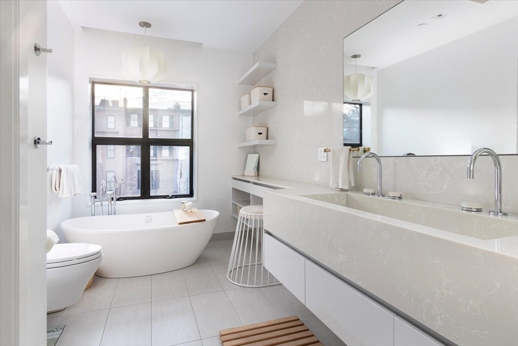 158 West Canton Street Boston, MA 02118 - Photo 9 of 25 a bathroom with a double vanity sink toilet mirror and bathtub