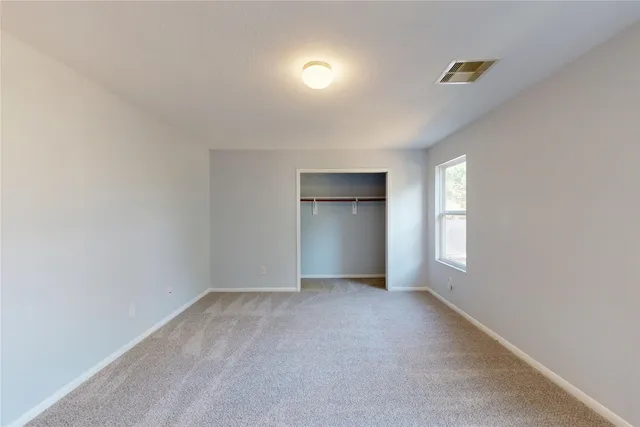 an empty room with windows and closet