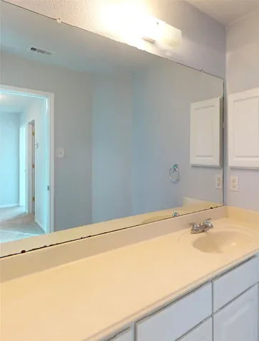 a bathroom with a sink and a white cabinet