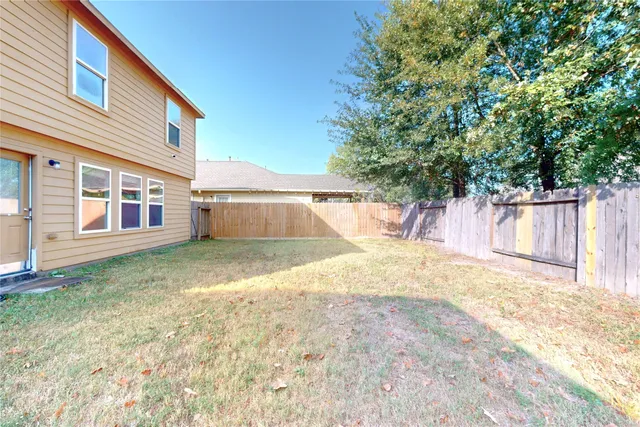 a view of a house with a backyard and a tree
