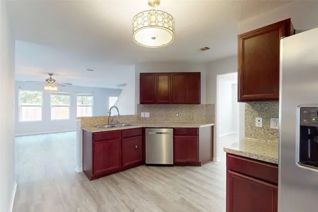 a kitchen with stainless steel appliances granite countertop wooden cabinets a stove a sink and dishwasher