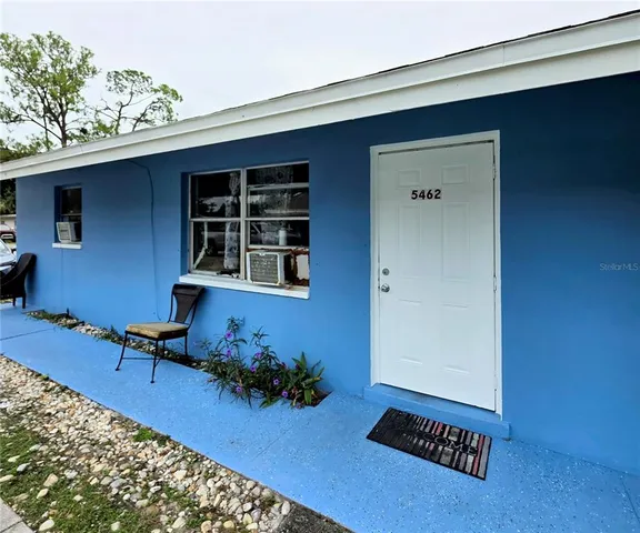 a view of patio with a table and chairs and potted plants