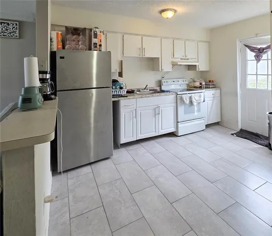 a kitchen with cabinets a refrigerator and a stove