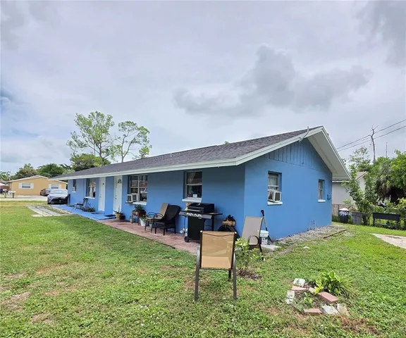 a backyard of a house with table and chairs