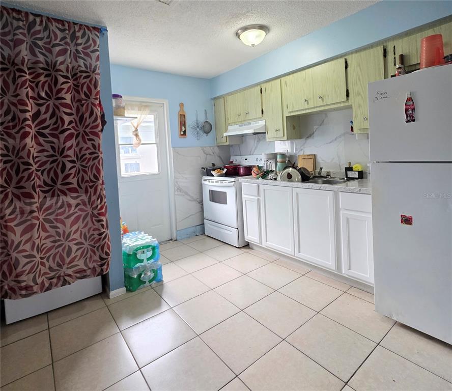 5462 Tenth Avenue Fort Myers, FL 33907 - Photo 6 of 20 a kitchen with a white cabinets and white appliances