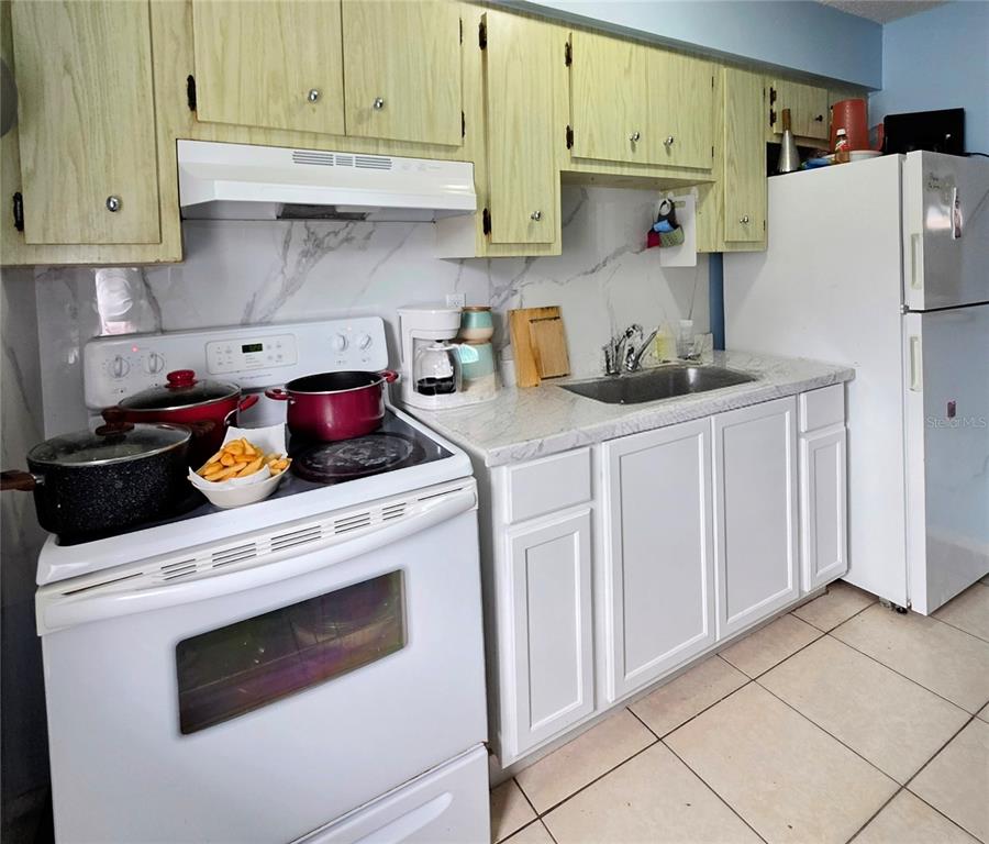 5462 Tenth Avenue Fort Myers, FL 33907 - Photo 7 of 20 a kitchen with stainless steel appliances granite countertop a refrigerator and a stove