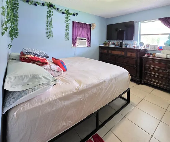 a bedroom with a bed and a flat screen tv