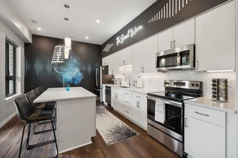 a kitchen with stainless steel appliances a stove a sink and a refrigerator