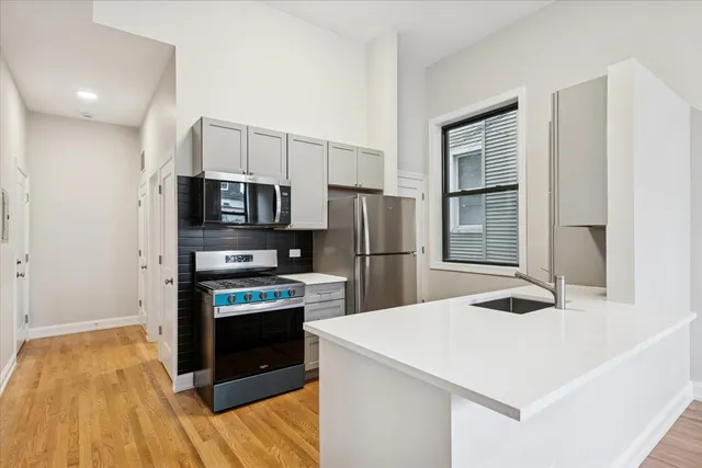 a kitchen with granite countertop a refrigerator and a stove top oven