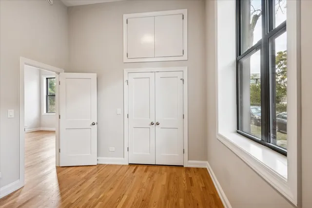 a view of empty room with wooden floor and fan