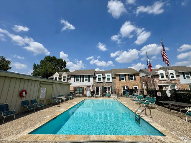 a view of a house with swimming pool and sitting area