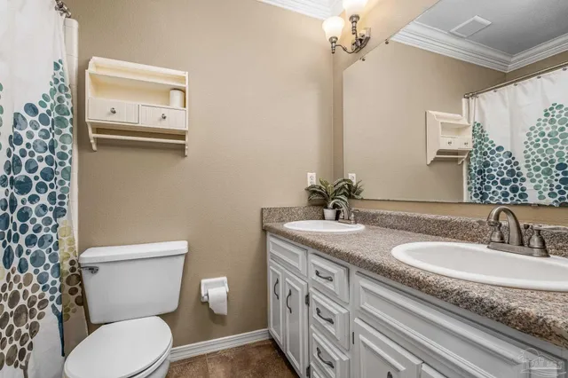 a bathroom with a granite countertop toilet sink and mirror