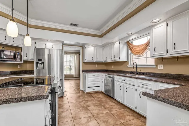 a view of a livingroom with a fireplace a ceiling fan and windows