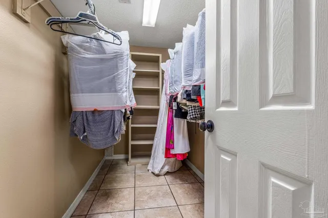a view of walk in closet with clothes