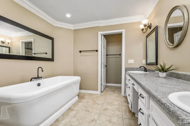a spacious bathroom with a granite countertop sink a mirror and a bathtub