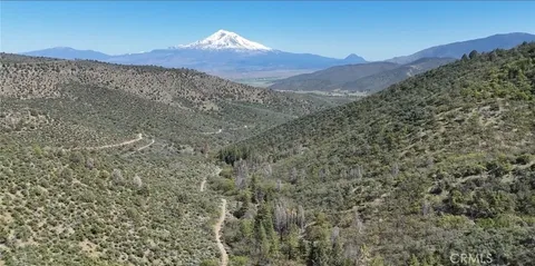 a view of a dry yard with mountains in the background