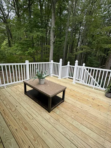 a view of balcony with wooden floor and fence