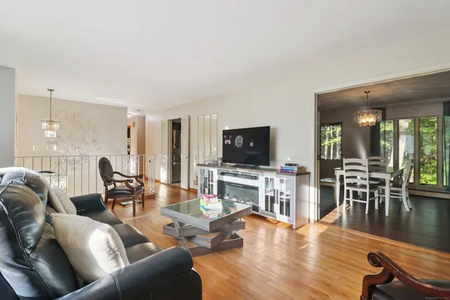 a living room with furniture flat screen tv and wooden floor