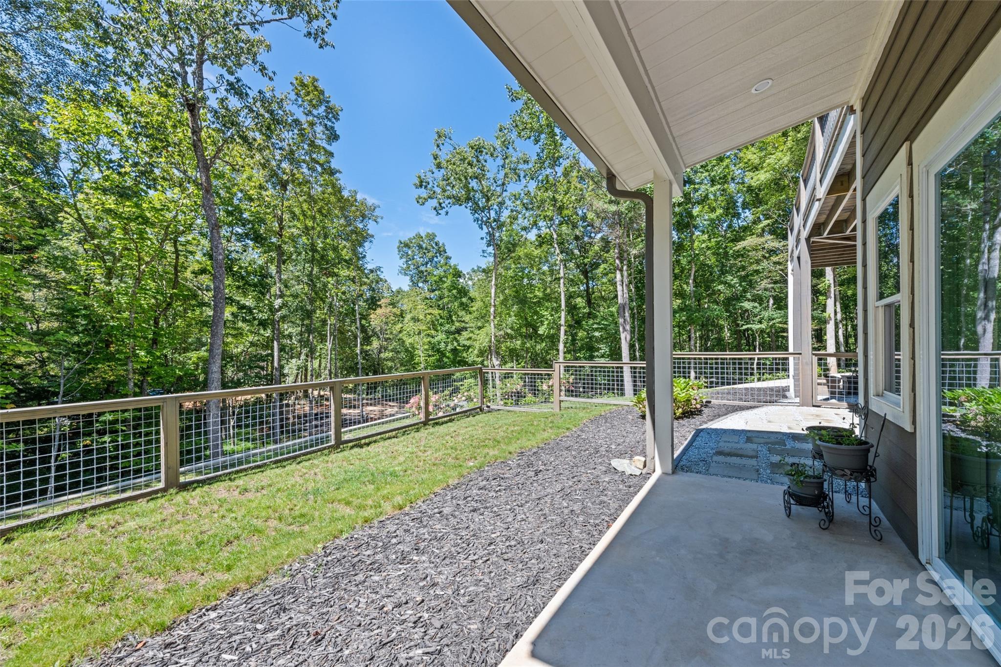 1185 Wallalieu Road Otto, NC 28763 - Photo 37 of 43 a view of a backyard with floor to ceiling window and wooden fence