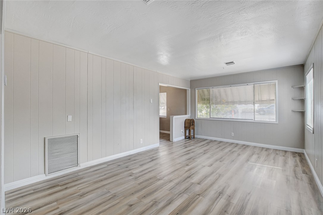 214 West Victory Road Henderson, NV 89015 - Photo 8 of 33 Natural light floods this living area with Luxury Vinyl flooring, offering a versatile space for relaxation.