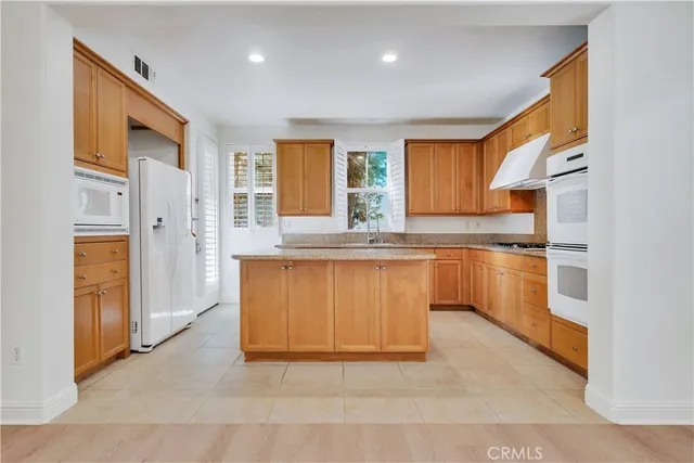 a kitchen with granite countertop white cabinets and white appliances