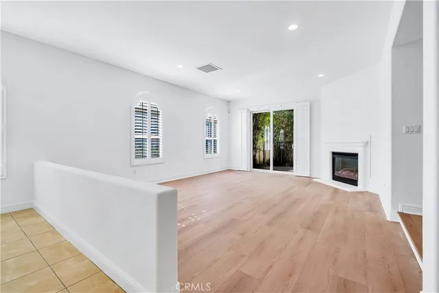 an empty room with windows and fireplace