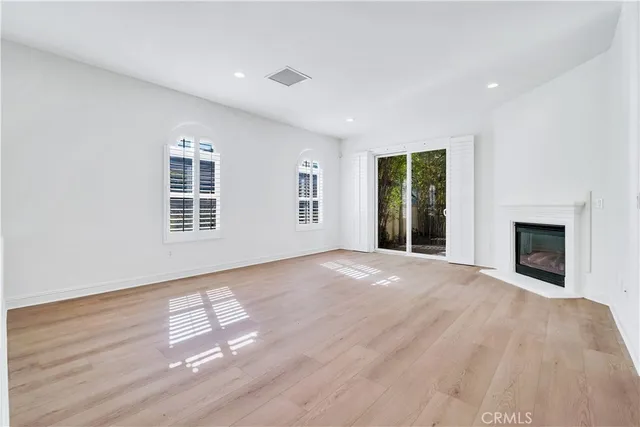 a view of an empty room with window and fire place