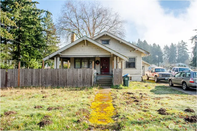 a view of a house with a yard patio and wooden fence