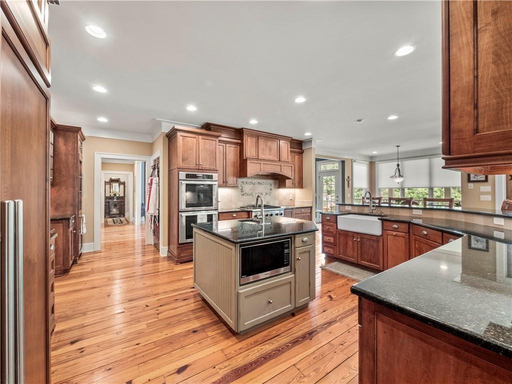 594 Peachtree Road Hoschton, GA 30548 - Photo 22 of 96 a kitchen with stainless steel appliances kitchen island granite countertop a stove refrigerator and cabinets