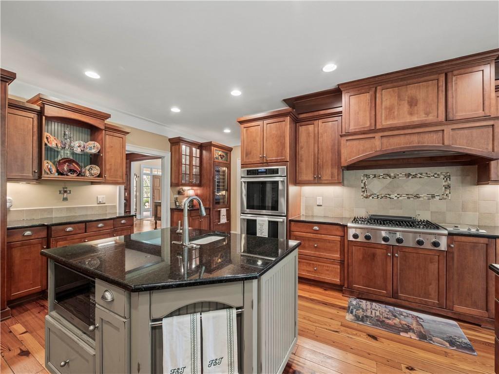 594 Peachtree Road Hoschton, GA 30548 - Photo 25 of 96 a kitchen with granite countertop kitchen island stainless steel appliances a sink stove and cabinets