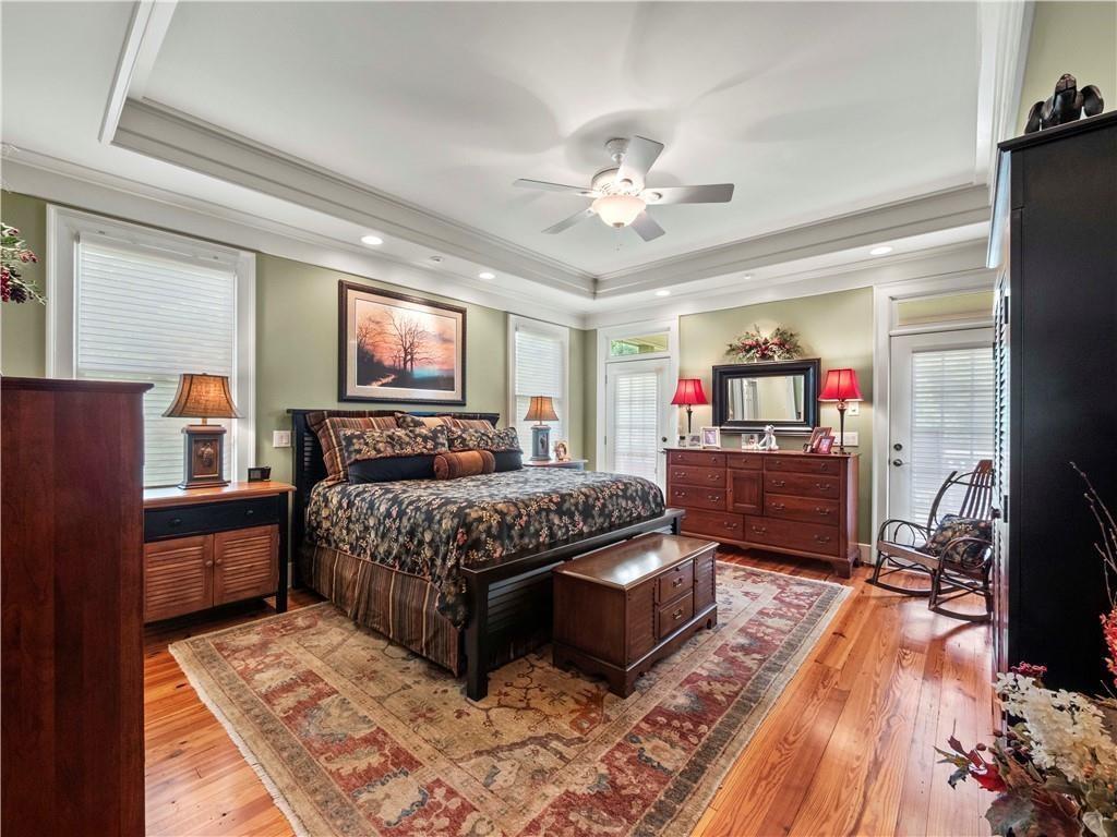 594 Peachtree Road Hoschton, GA 30548 - Photo 35 of 96 a bedroom with a large bed and a chandelier