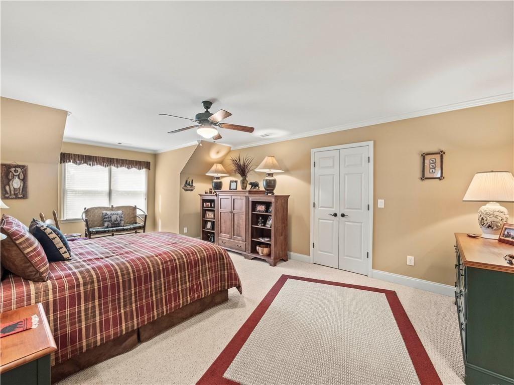 594 Peachtree Road Hoschton, GA 30548 - Photo 52 of 96 a bedroom with a large bed and a chandelier