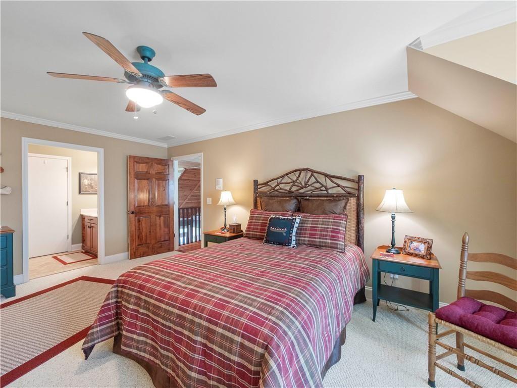 594 Peachtree Road Hoschton, GA 30548 - Photo 53 of 96 a bedroom with a bed and a chandelier