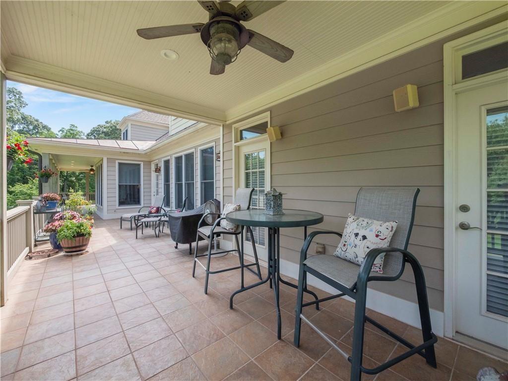 594 Peachtree Road Hoschton, GA 30548 - Photo 71 of 96 a view of a patio with dining table and chairs with potted plants