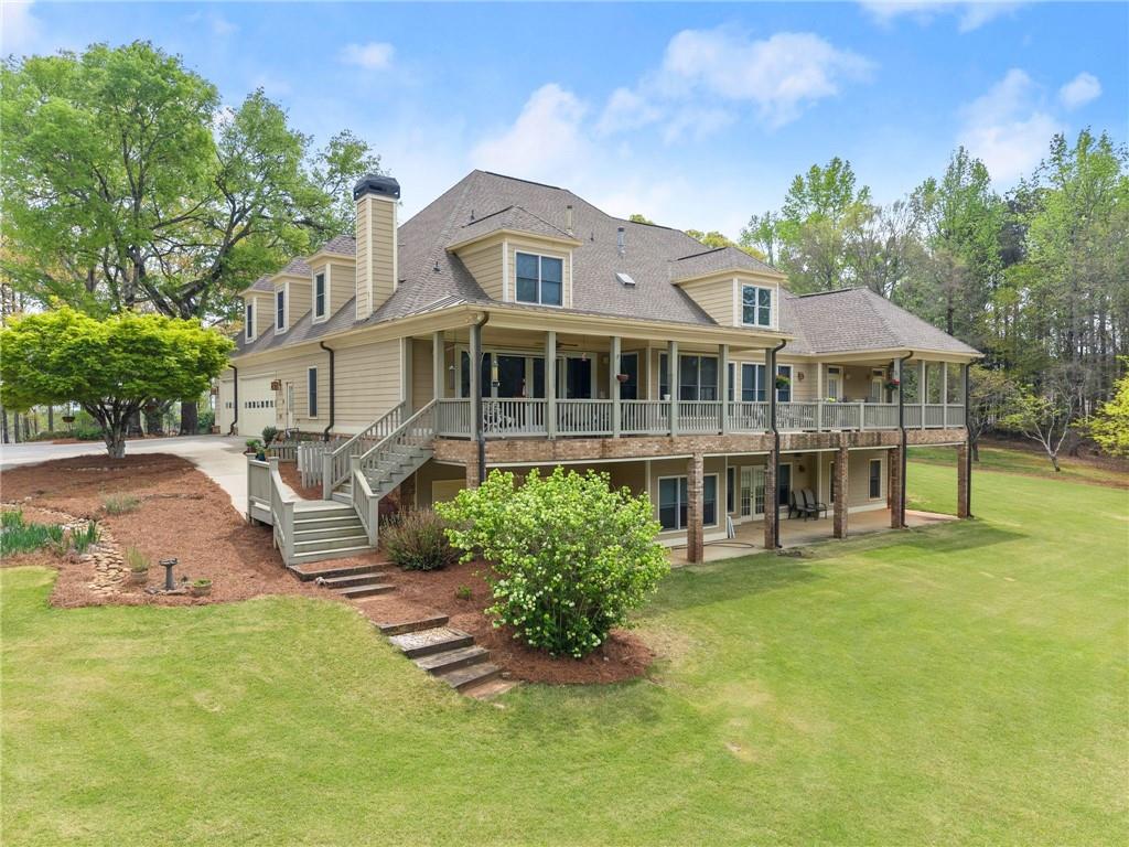 594 Peachtree Road Hoschton, GA 30548 - Photo 80 of 96 a front view of a house with a garden and lake view