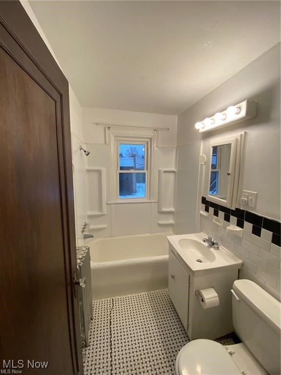 642 East Wilbeth Road Akron, OH 44306 - Photo 13 of 39 Unit 1 Full bathroom featuring tub / shower combination, toilet, tile walls, radiator, and vanity