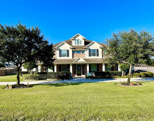 a front view of a house with swimming pool and trees
