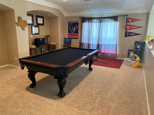 a room with furniture pool table and window