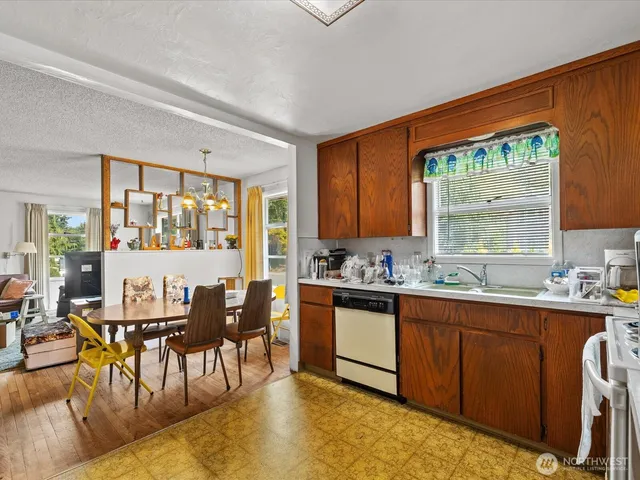 a kitchen with stainless steel appliances kitchen island granite countertop a table chairs stove and sink