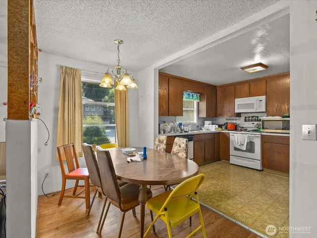 a kitchen with a table chairs refrigerator and cabinets