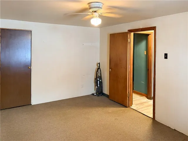 an empty room with closet and a chandelier fan