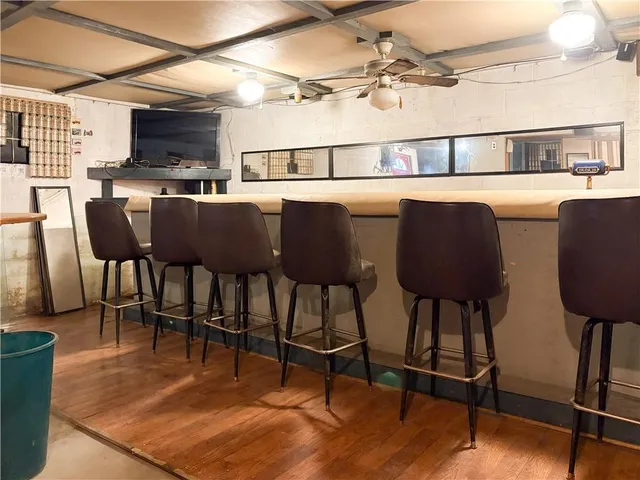 a living room with a couch a dining table and chairs with wooden floor