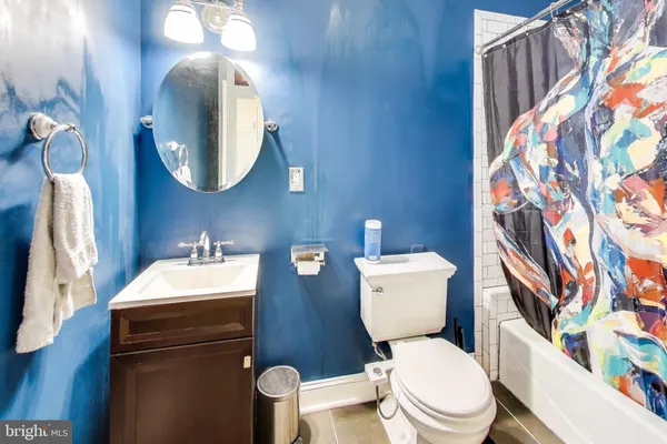 a bathroom with a toilet sink vanity and mirror
