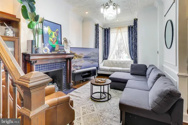 a living room with furniture a fireplace and a chandelier