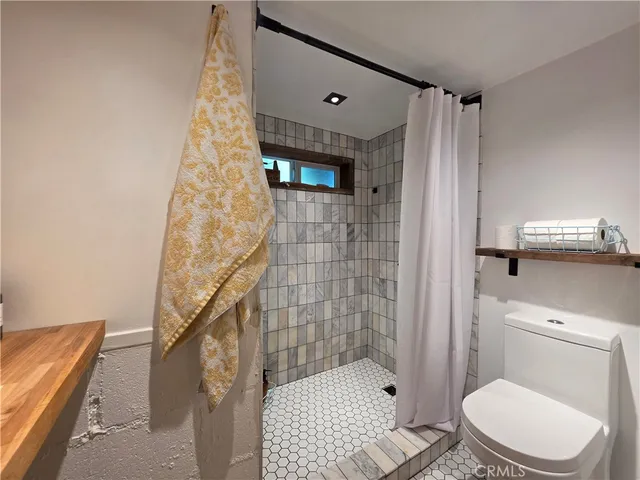 a bathroom with a toilet and a shower