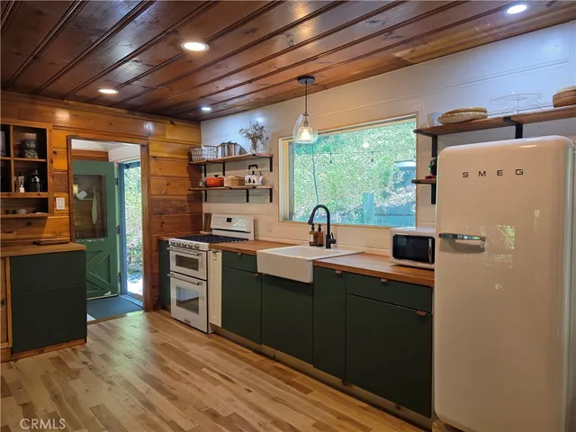 a kitchen with stainless steel appliances a sink cabinets and a wooden floor