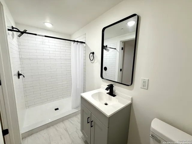 a bathroom with a sink toilet and shower