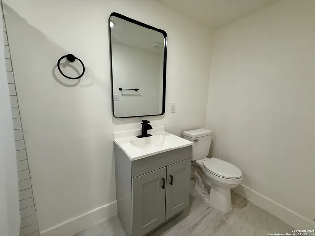 a bathroom with a toilet sink and mirror
