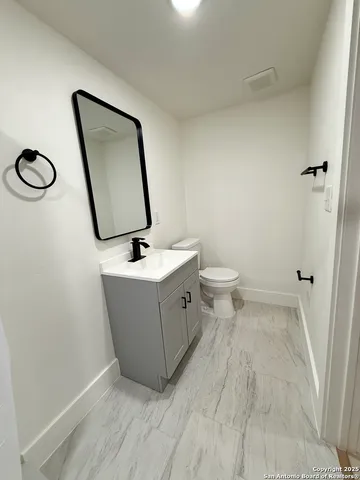 a bathroom with a toilet a sink and mirror