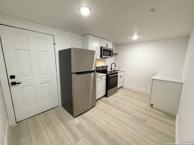 a kitchen with stainless steel appliances a refrigerator and a stove top oven